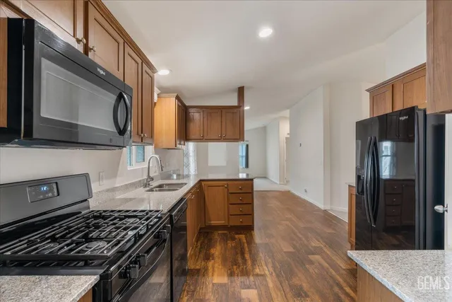 a kitchen with stainless steel appliances granite countertop a stove refrigerator and microwave