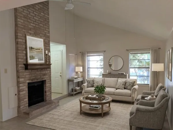 a living room with furniture a fireplace and a large window