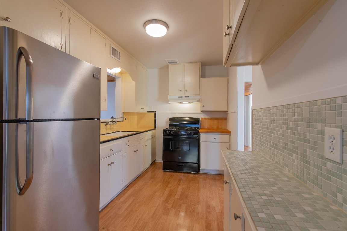 5515 Roosevelt Avenue Austin, TX 78756 - Photo 4 of 17 a kitchen with a refrigerator and a stove top oven