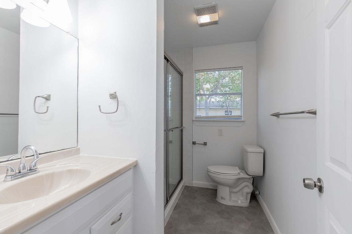 5515 Roosevelt Avenue Austin, TX 78756 - Photo 10 of 17 a bathroom with a granite countertop toilet a sink and a mirror