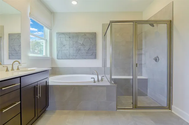 a bathroom with a tub double sink window and mirror