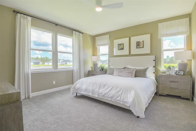a bedroom with a bed potted plant on the dresser and a window