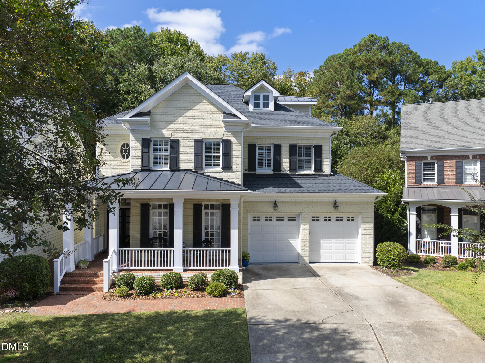 a front view of a house with a yard and trees