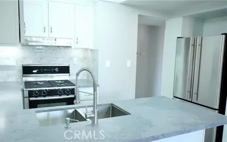 a kitchen with a stove and white cabinets