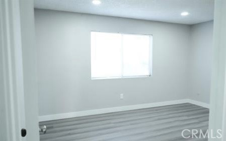 2255 Cahuilla Street, Unit 55 Colton, CA 92324 - Photo 4 of 6 a view of an empty room with wooden floor and a window