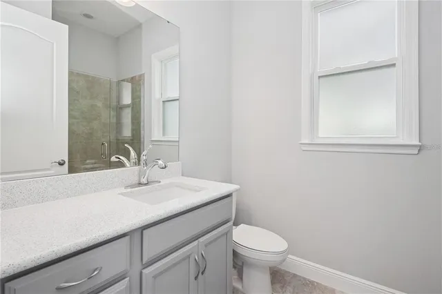 a bathroom with a granite countertop toilet and a shower