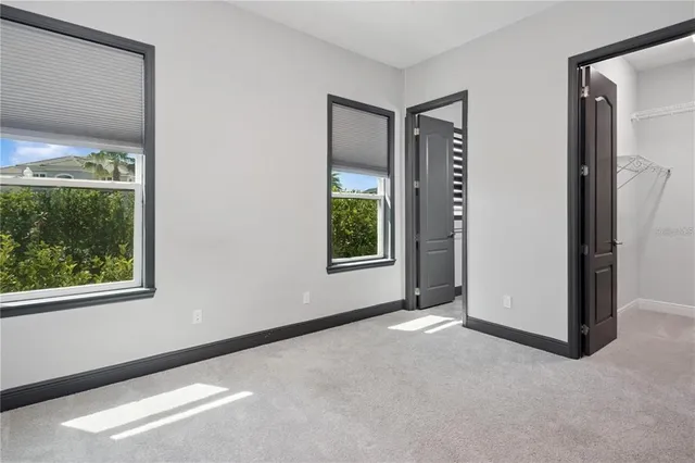 an empty room with windows and closet