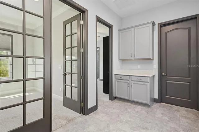 a view of an empty room with window and a kitchen