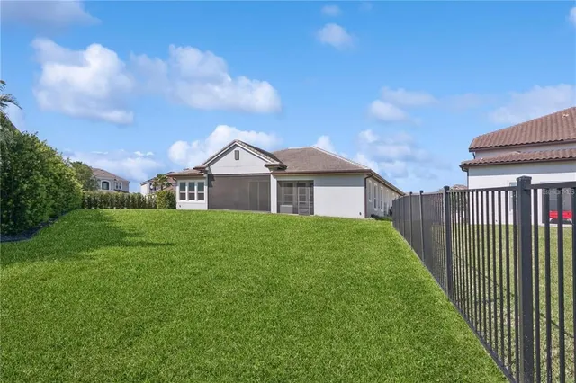 a view of a house with a big yard plants and large trees