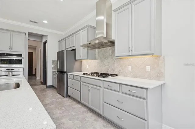 a kitchen with stainless steel appliances granite countertop a stove a refrigerator and a white cabinets