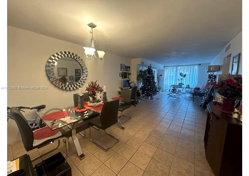 1800 Sans Souci Boulevard, Unit 239 North Miami, FL 33181 - Photo 3 of 15 a living room with furniture a chandelier and a dining table