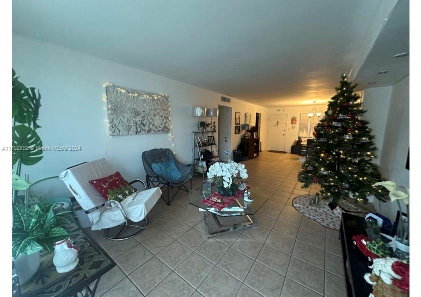 1800 Sans Souci Boulevard, Unit 239 North Miami, FL 33181 - Photo 6 of 15 a living room with furniture and flowers