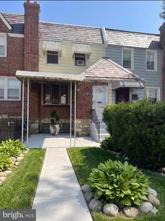 a front view of a house with a yard and potted plants