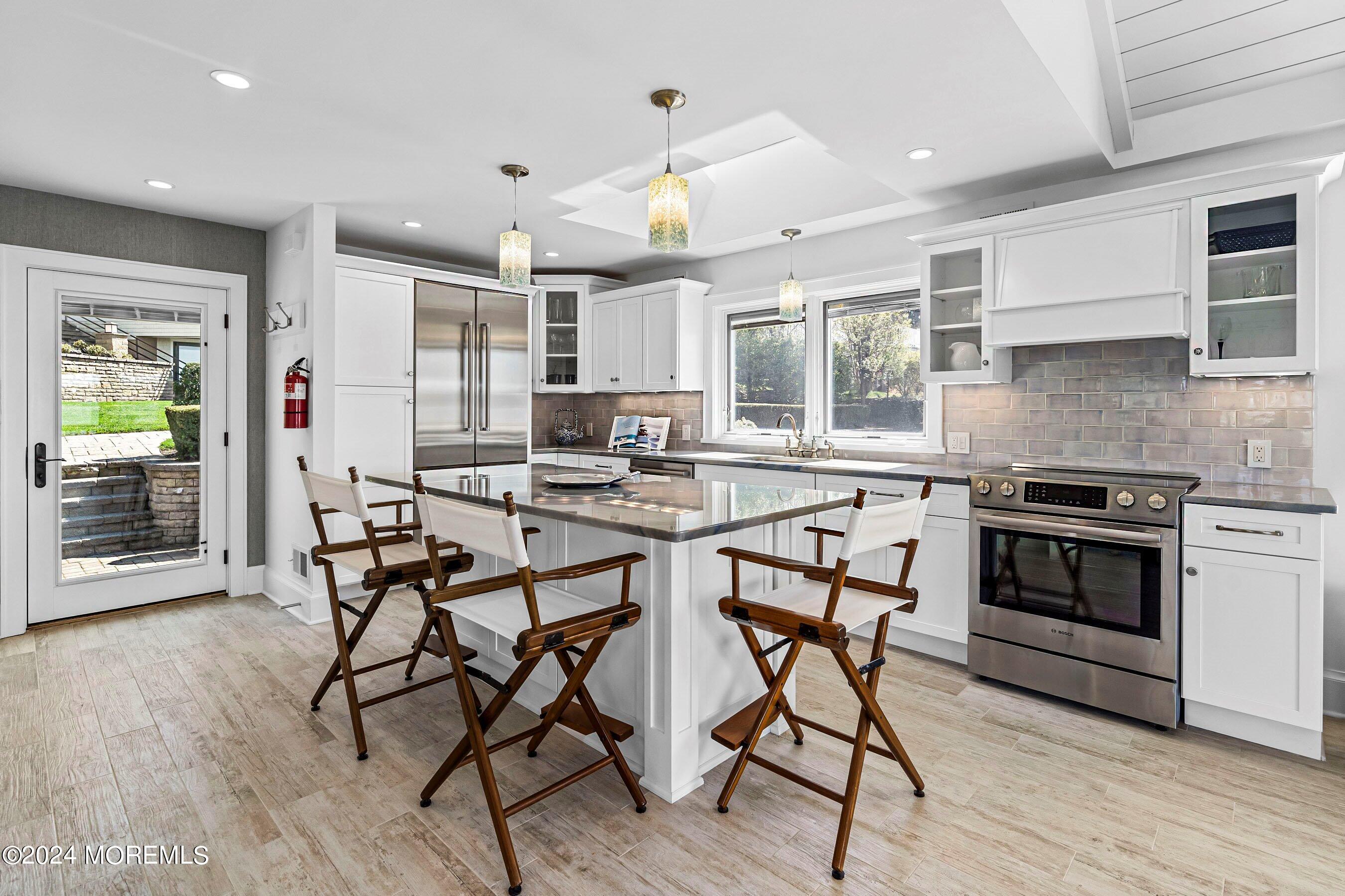 30 Alston Court Red Bank, NJ 07701 - Photo 76 of 103 a kitchen with stainless steel appliances kitchen island granite countertop a stove top oven a sink dishwasher a dining table and chairs with wooden floor