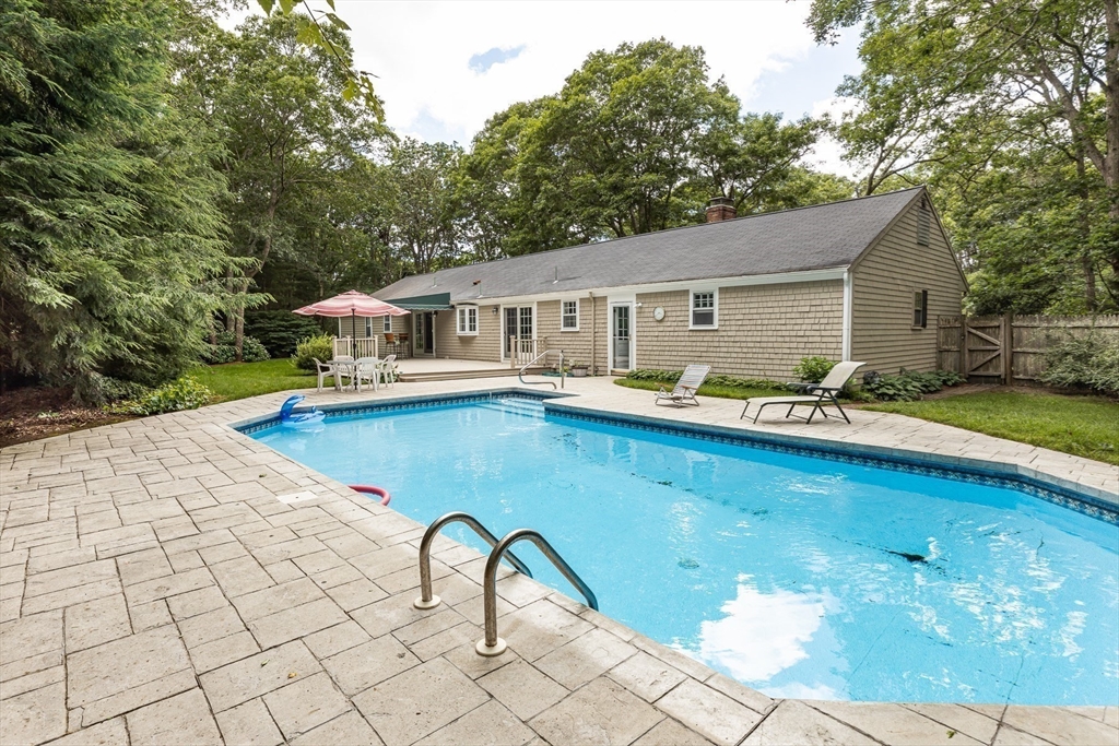 25 Naushon Circle Barnstable, MA 02632 - Photo 3 of 23 a backyard of a house with table and chairs