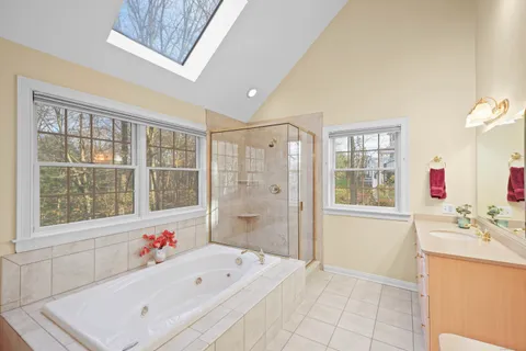 a bathroom with a tub sink and next to a window