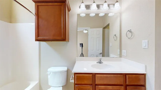 a bathroom with a sink a toilet and mirror
