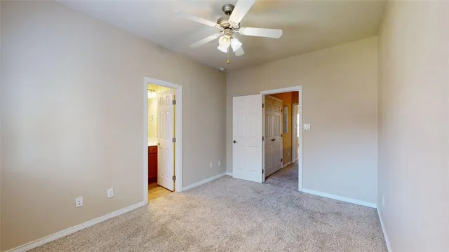 an empty room with a ceiling fan and a window