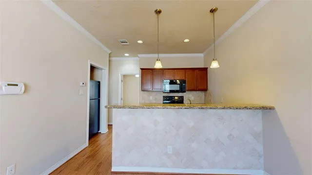 a view of a kitchen with kitchen island a sink stainless steel appliances and cabinets