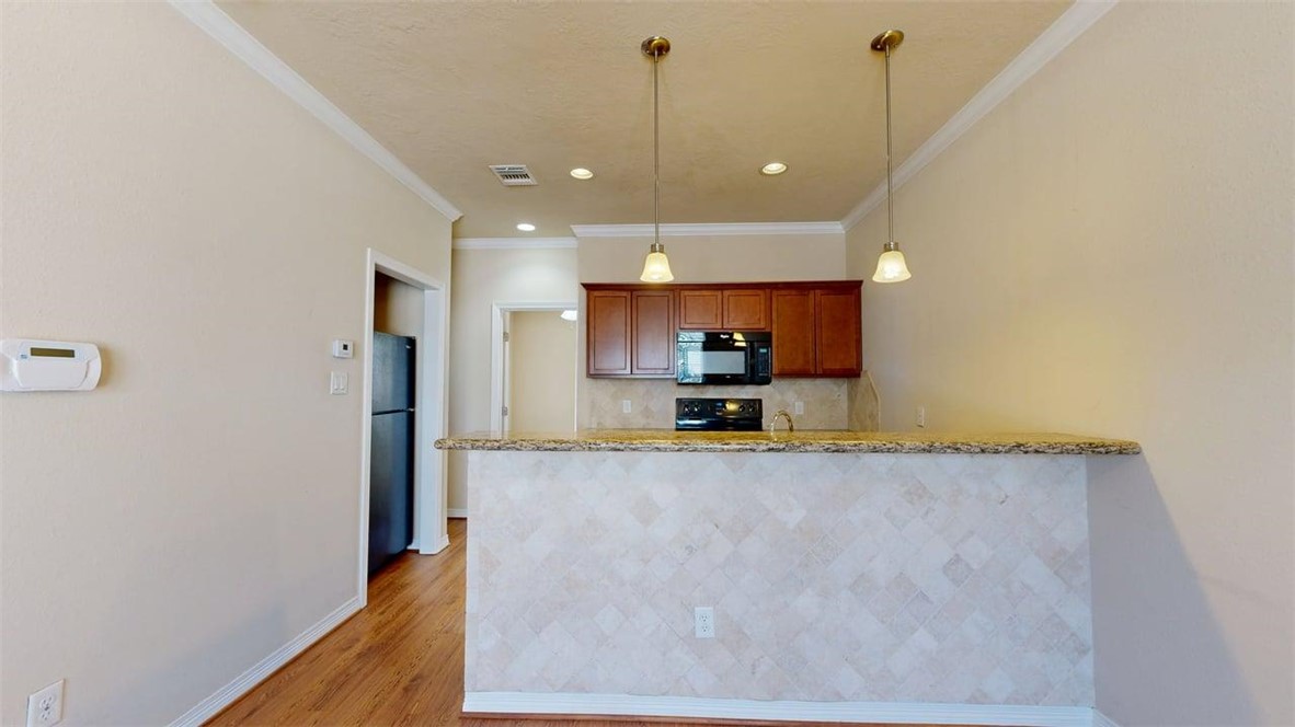 1198 Jones-Butler Road, Unit 2603 College Station, TX 77840 - Photo 5 of 29 a view of a kitchen with kitchen island a sink stainless steel appliances and cabinets