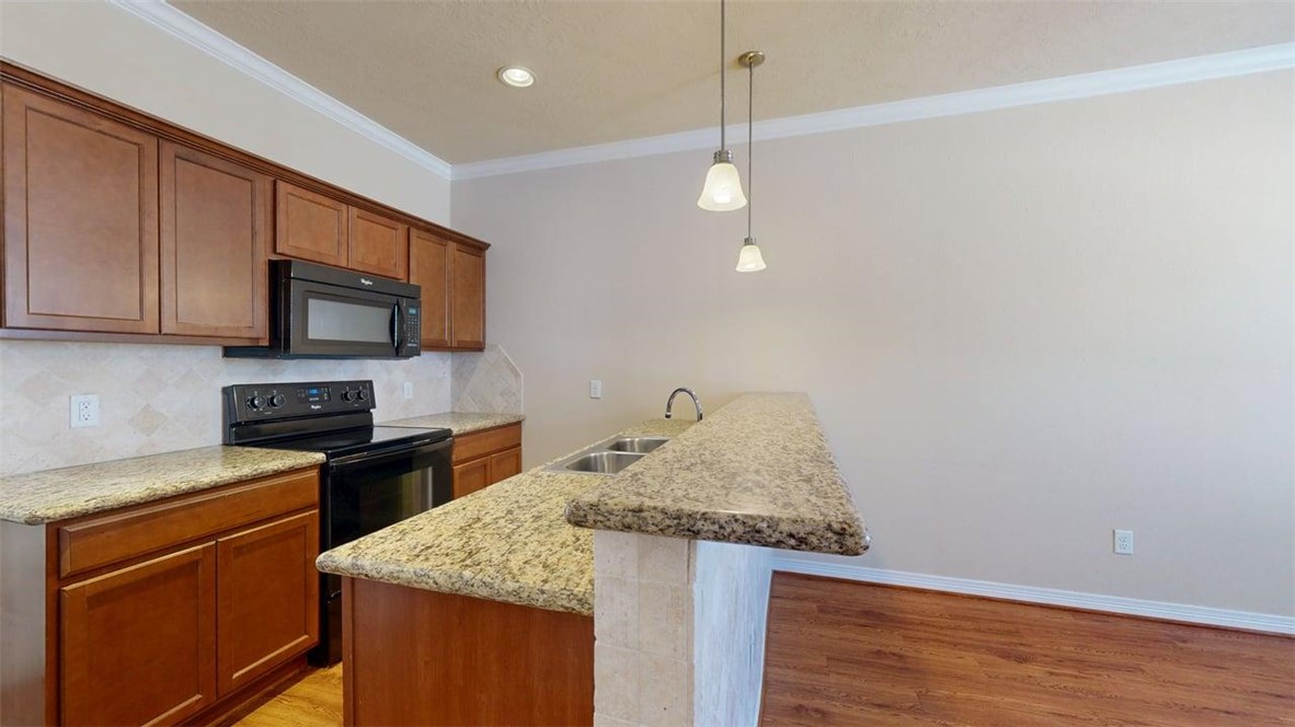1198 Jones-Butler Road, Unit 2603 College Station, TX 77840 - Photo 6 of 29 a kitchen with kitchen island granite countertop stainless steel appliances and wooden cabinets