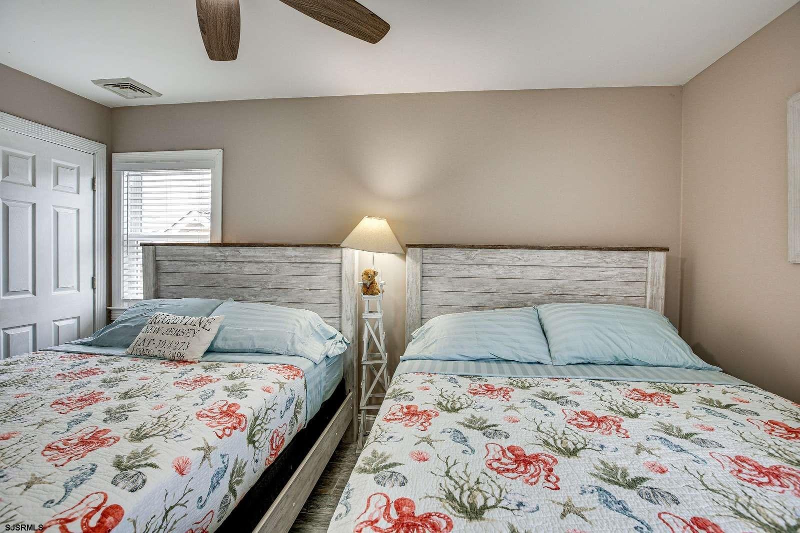 210 34th Street South, Unit 2 Brigantine, NJ 08203 - Photo 16 of 32 a bedroom with a bed and a lamp on dresser