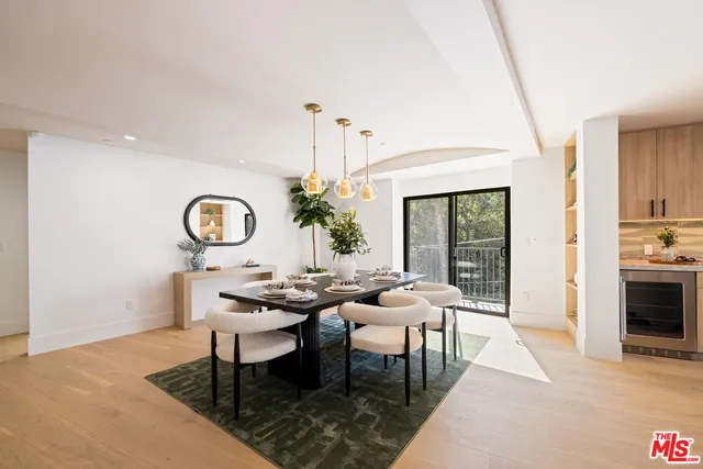 a dining room with wooden floor a chandelier a wooden table and chairs