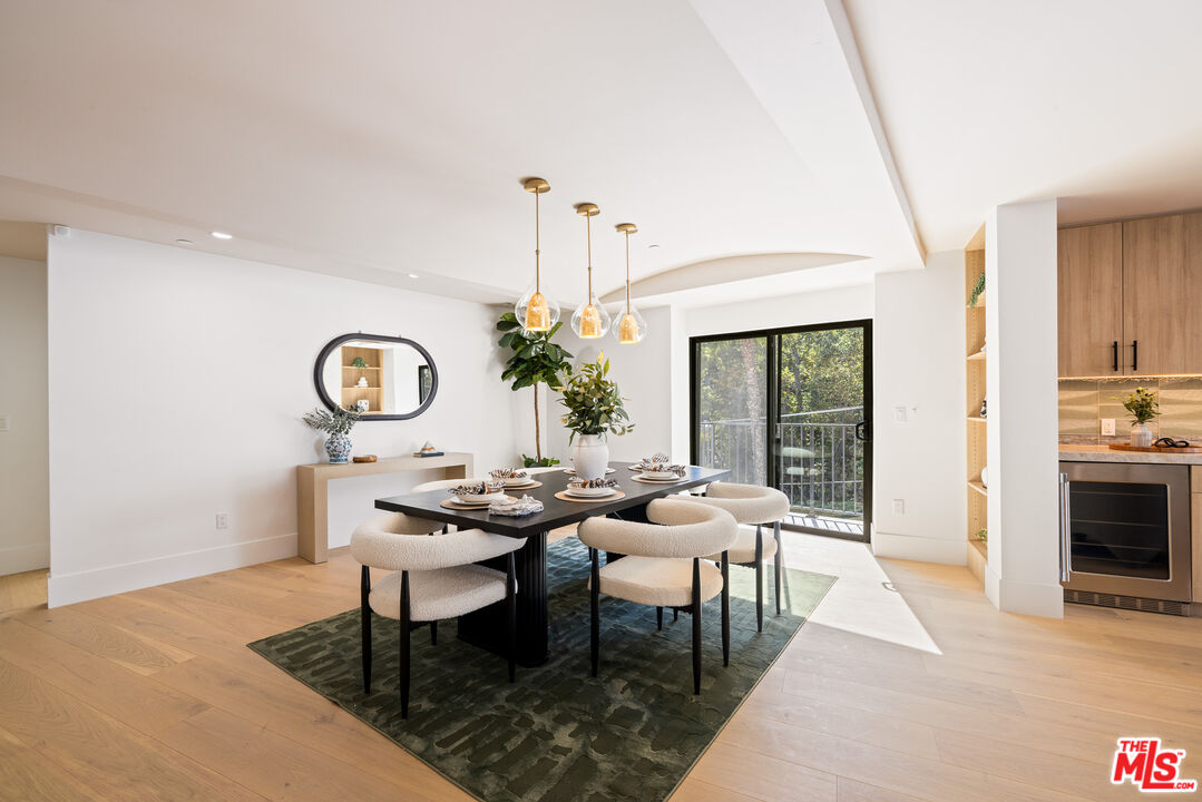 2256 Nichols Canyon Road Los Angeles, CA 90046 - Photo 11 of 45 a dining room with wooden floor a chandelier a wooden table and chairs