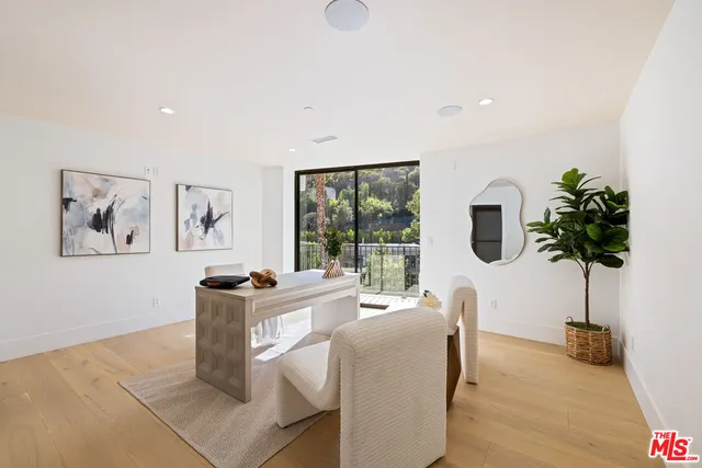 a living room with furniture a potted plant and a large window