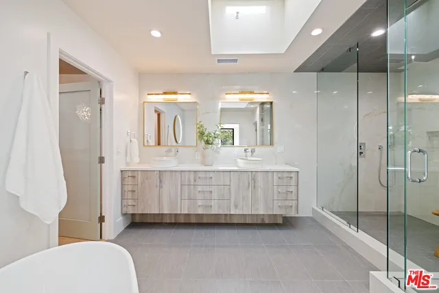 a bathroom with a double vanity sink mirror and shower