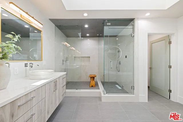 a bathroom with a tub a sink and mirror