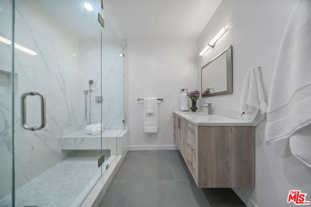 a bathroom with a double vanity sink a toilet and shower