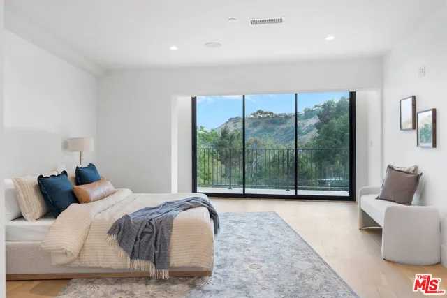 a bedroom with a bed and a large window