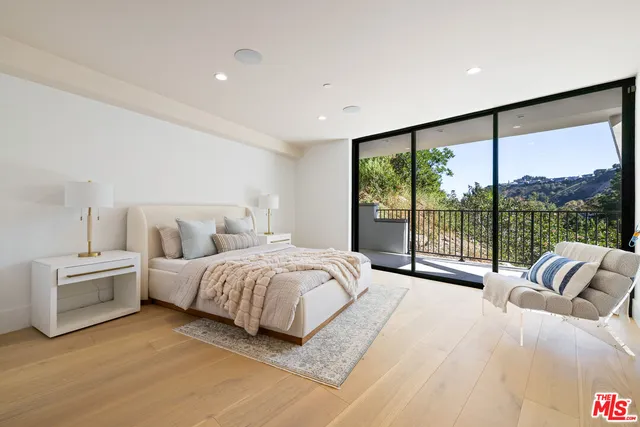 a spacious bedroom with a large bed and a large window