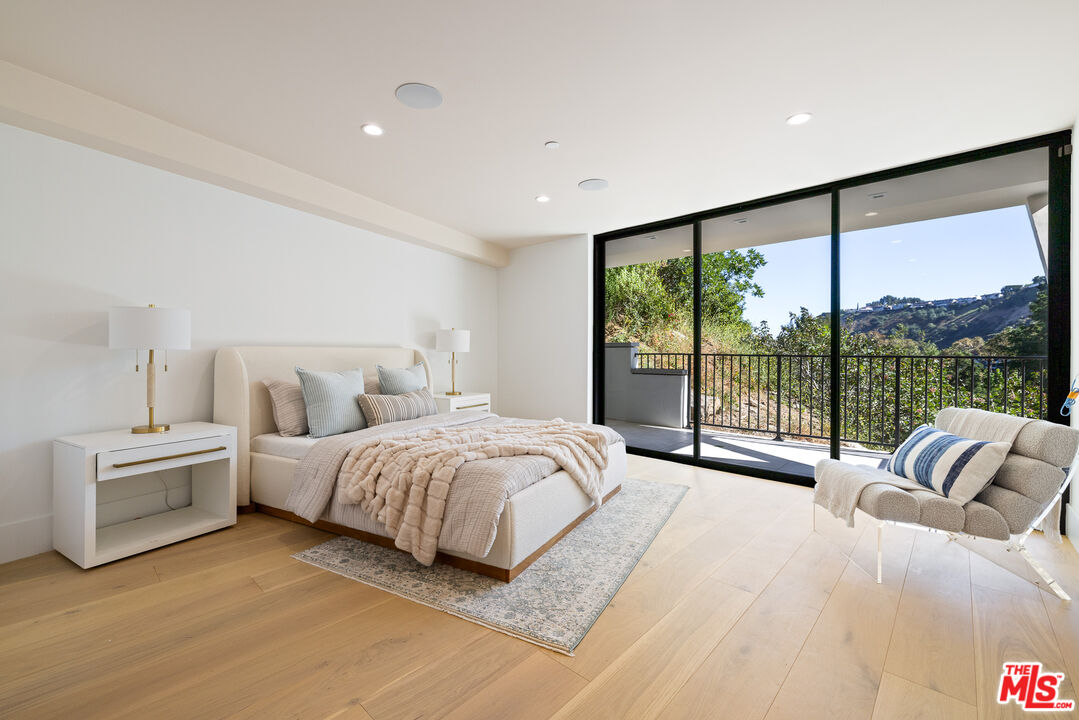 2256 Nichols Canyon Road Los Angeles, CA 90046 - Photo 30 of 45 a spacious bedroom with a large bed and a large window