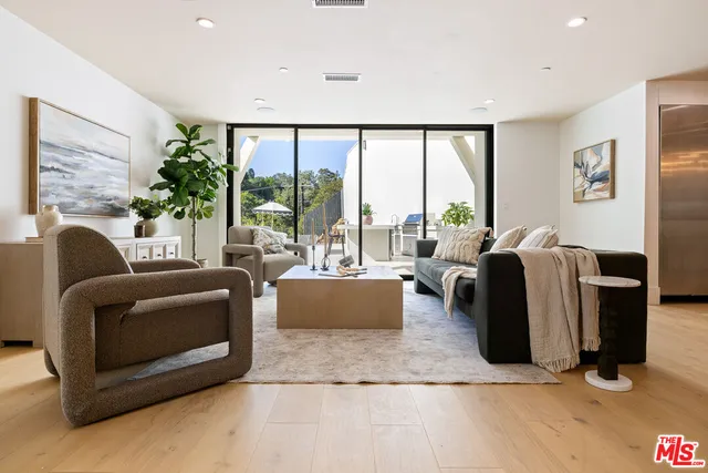 a living room with furniture large windows and a flat screen tv