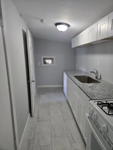 a kitchen with granite countertop stainless steel appliances and white cabinets