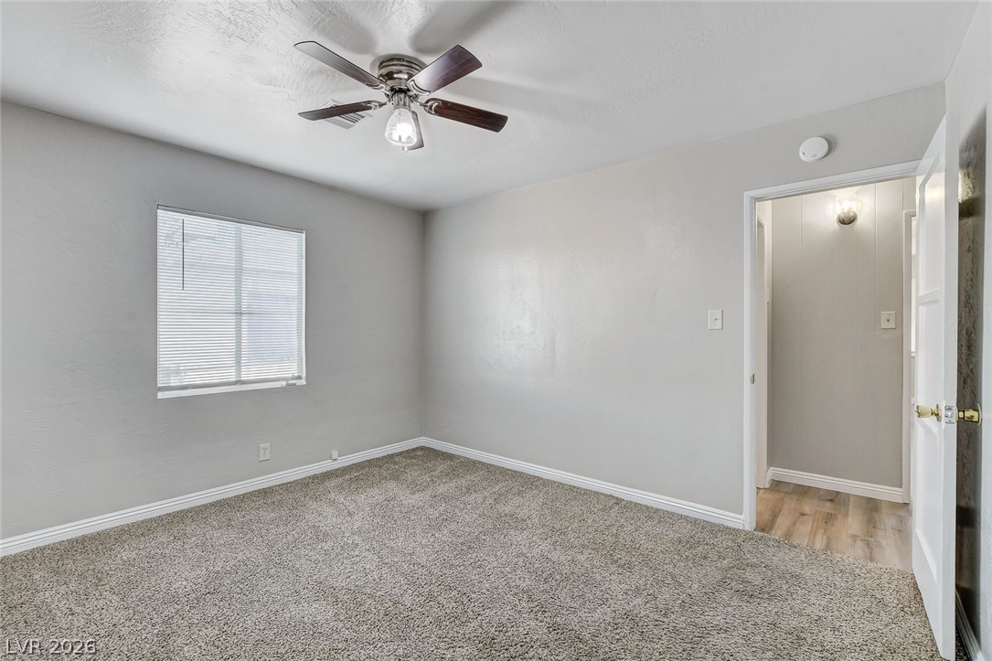 214 West Victory Road Henderson, NV 89015 - Photo 15 of 33 A comfortable retreat, this bedroom offers soft carpeting and a ceiling fan for year-round comfort.