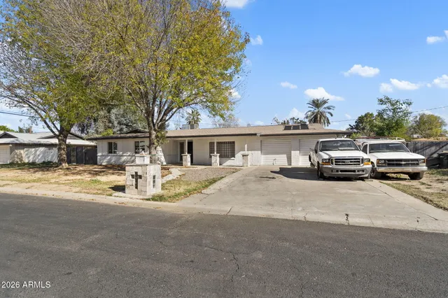 a front view of a house with cars parked