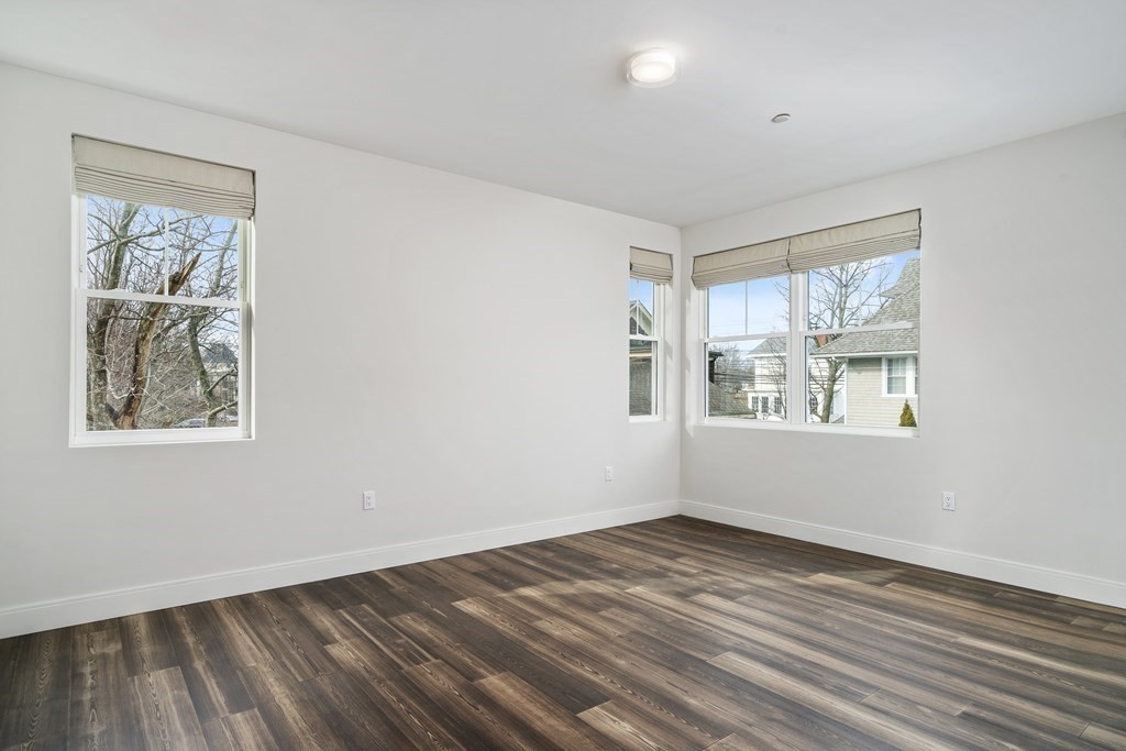429 Cherry Street, Unit 12 Newton, MA 02465 - Photo 11 of 20 an empty room with wooden floor and windows