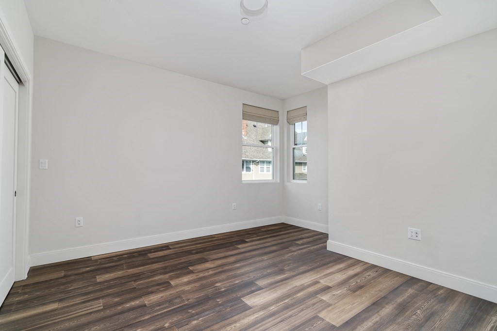 429 Cherry Street, Unit 12 Newton, MA 02465 - Photo 12 of 20 a view of an empty room with wooden floor and a window