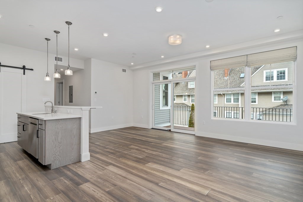 429 Cherry Street, Unit 12 Newton, MA 02465 - Photo 3 of 20 a view of an empty room with wooden floor and a window