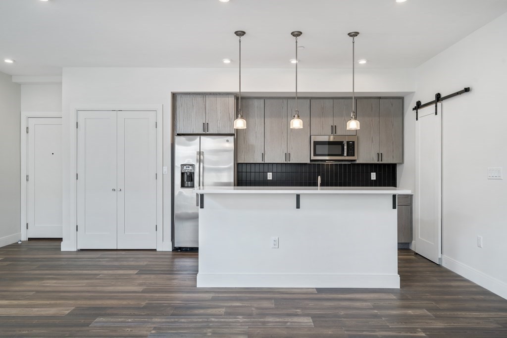 429 Cherry Street, Unit 12 Newton, MA 02465 - Photo 6 of 20 a large kitchen with stainless steel appliances granite countertop a refrigerator a sink and a wooden floors