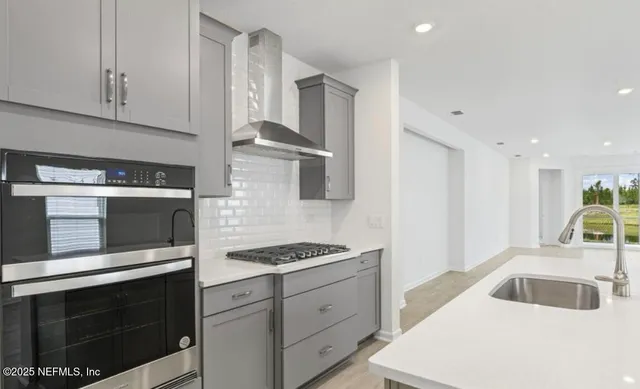 a kitchen with granite countertop a sink stove and cabinets