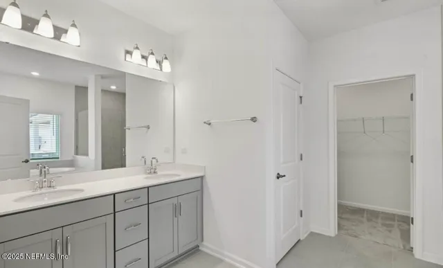 a bathroom with double vanity sink a vanity and a mirror