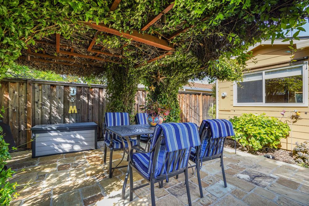 475 Rincon Avenue Sunnyvale, CA 94086 - Photo 51 of 58 a view of a patio with table and chairs potted plants and large tree