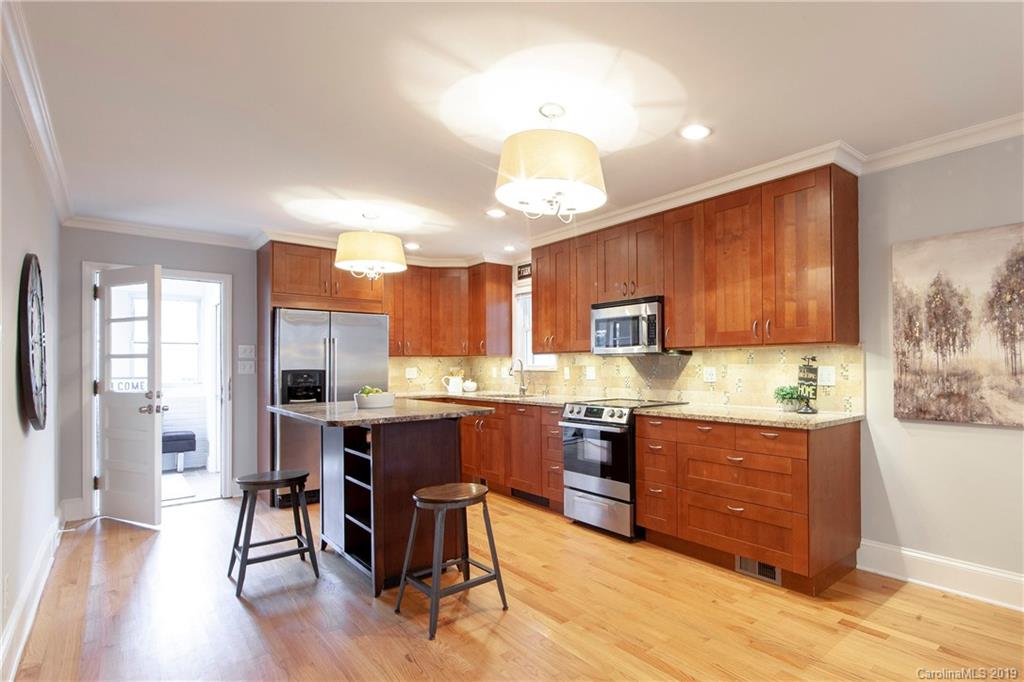 4143 Pineview Road Charlotte, NC 28211 - Photo 6 of 22 a kitchen with a table chairs refrigerator and wooden cabinets