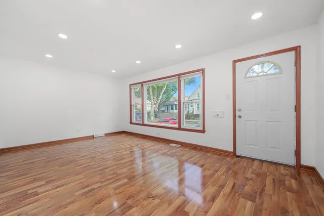 a view of an empty room with a window and a ceiling fan