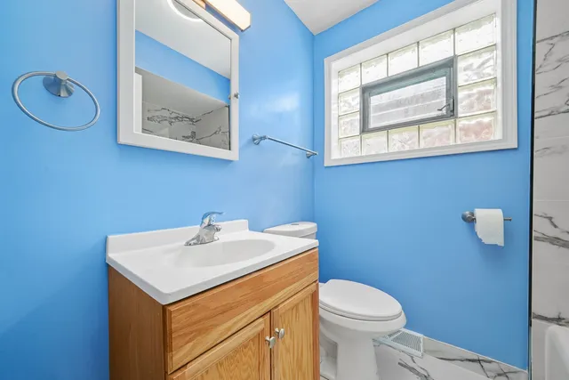a bathroom with a sink mirror and toilet