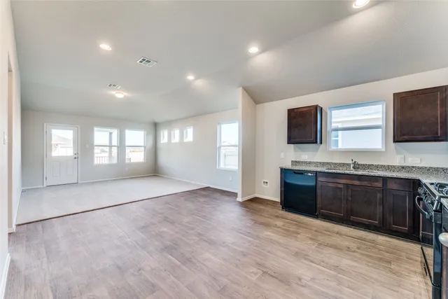 a large kitchen with kitchen island granite countertop a sink and a stove top oven